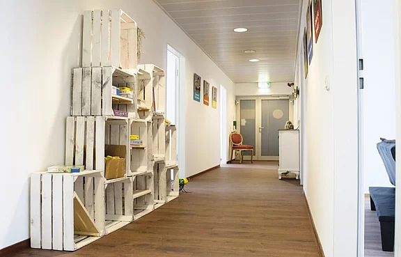 Flur in dem Holzkisten zu einem Regal angeordnet sind