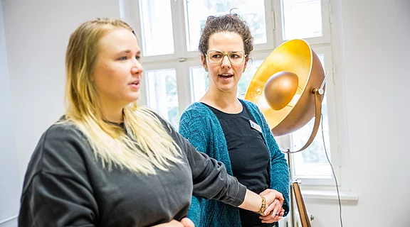 zwei Frauen die im Raum stehen und etwas anschauen