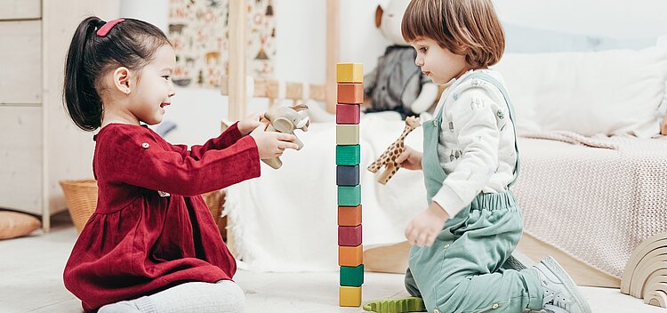 Zwei Kinder spielen in einem Spielzimmer.