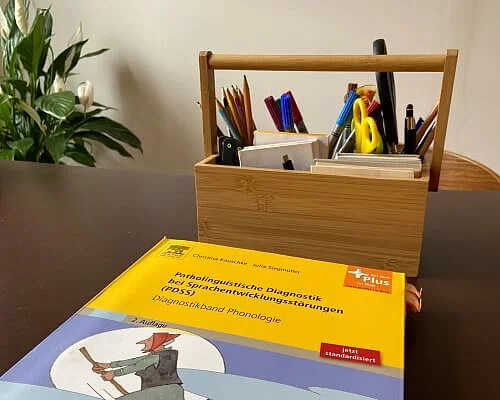 Tisch mit Stiftebox und Lernbuch